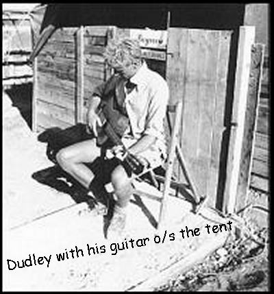 Dudley playing the guitar o/s the tent
